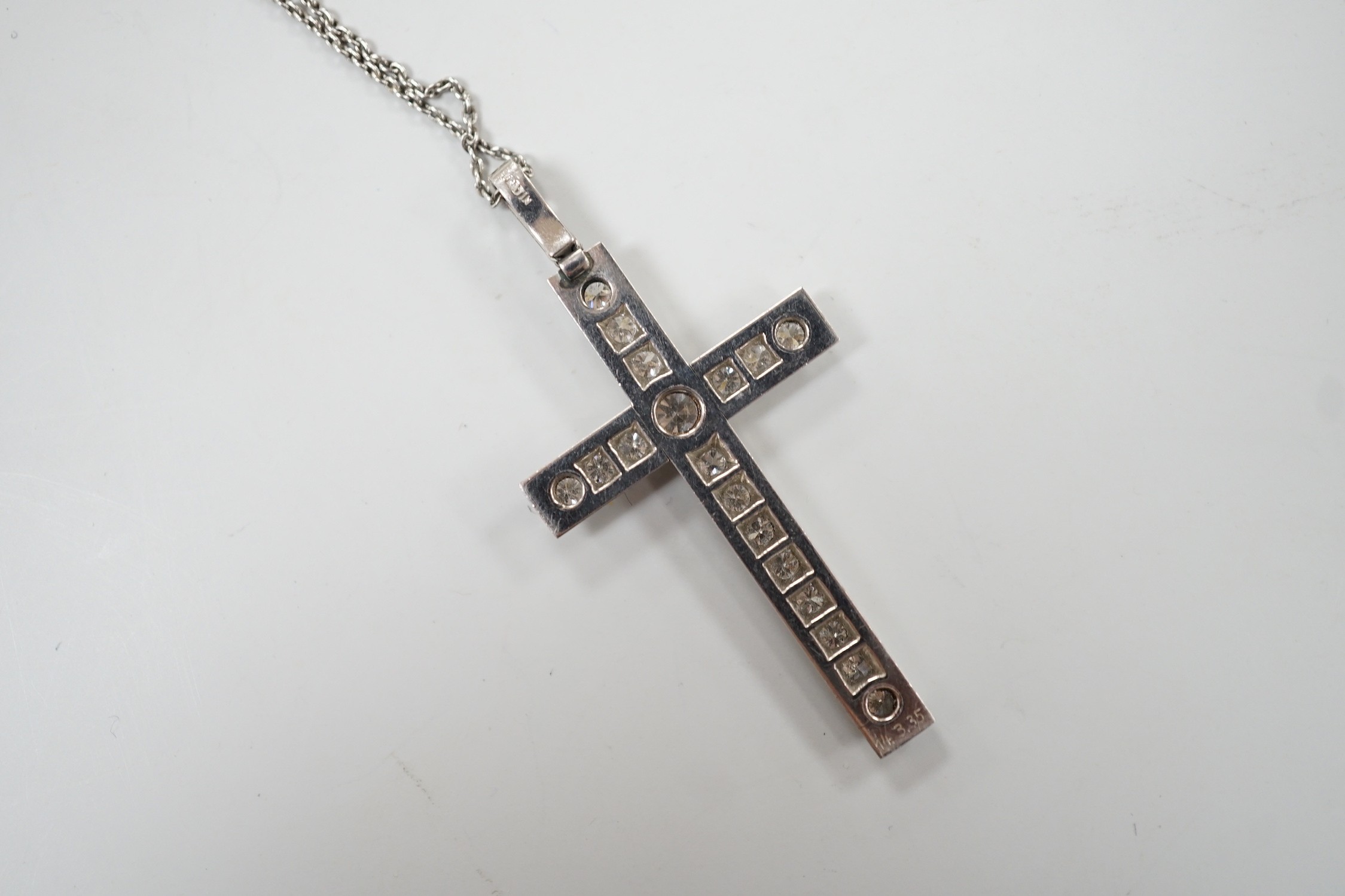 A white metal(stamped platin) and diamond set cross pendant, overall 46mm, on a white metal chain, 70cm, gross weight 12.1 grams
